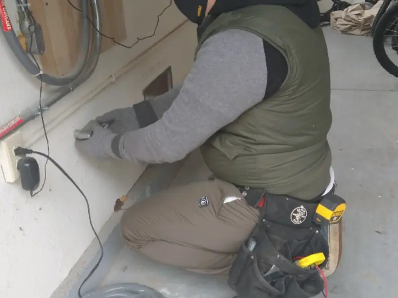 Electrician performing outlet wiring in a Webster Groves garage